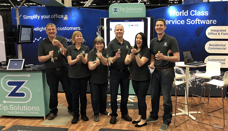 photo of Zip Solutions field service management software company employees celebrating in their trade show booth