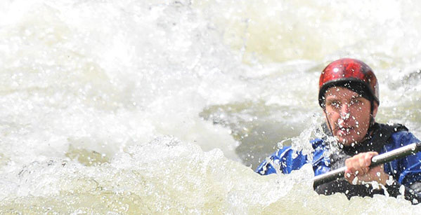 Russ Duker kayaking in rapids as a metaphor of essential businesses' challenge of managing remote employees